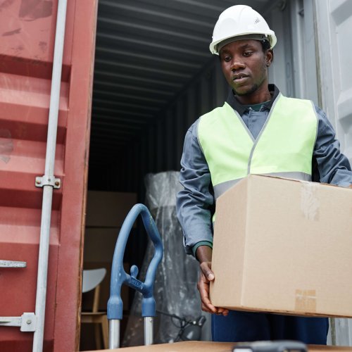 Man unloading boxes from container at shipping docks